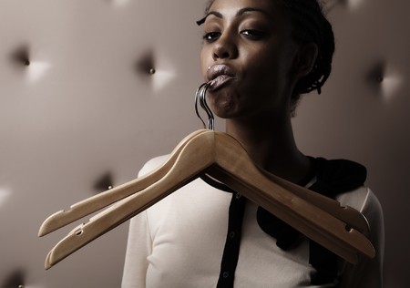 African woman with hangers trailing for a her lipの写真素材