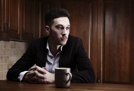 Man sitting at the kitchen counterの写真素材