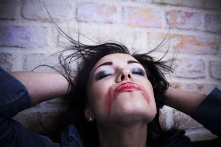 Depressed young brunette with smeared lipstick on her face.