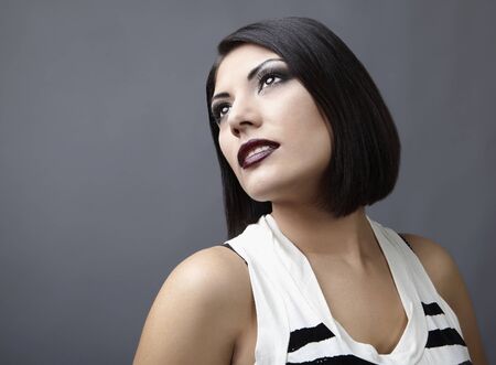 Beautiful brunette with an accurate hairdress dressed in a striped t-shirt.の写真素材