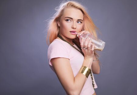 Young teenager girl drinking a coffee  Studio shoot on gray  の写真素材