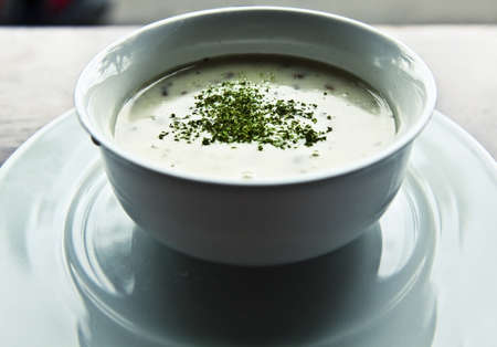 Mushroom soup with parsley in white ceramic bowlの写真素材