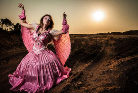Attractive romantic woman on beautiful pink dress pose outdoor  の写真素材