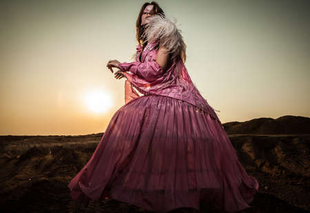 Attractive romantic woman on beautiful pink dress pose outdoor  の写真素材