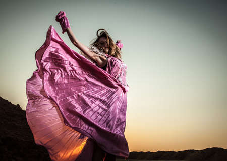 Attractive romantic woman on beautiful pink dress pose outdoor  の写真素材