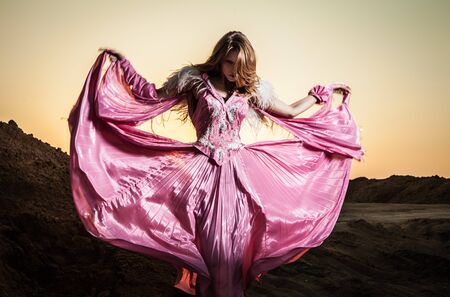 Attractive romantic woman on beautiful pink dress pose outdoor  の写真素材