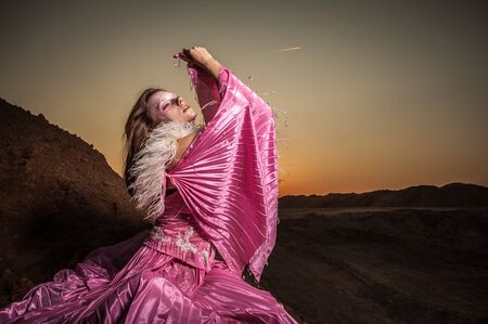 Attractive romantic woman on beautiful pink dress pose outdoor  の写真素材