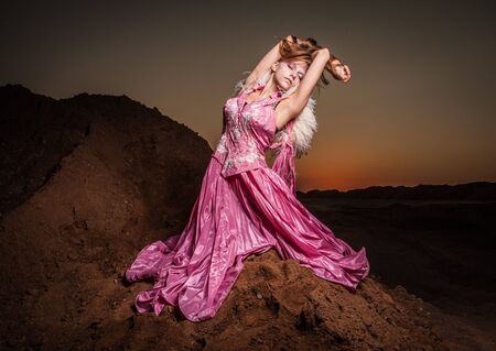 Attractive romantic woman on beautiful pink dress pose outdoor  の写真素材