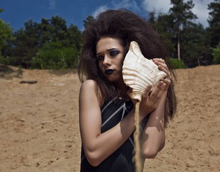 Outdoor fashion shot of young woman in swimsuit  の写真素材