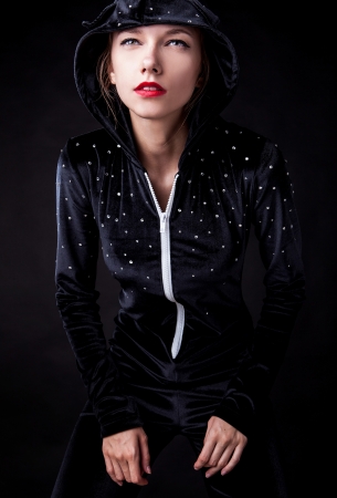 Posing woman in fashionable costume on dark background  の写真素材