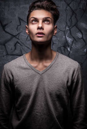 Elegant young handsome man on grunge background  Studio fashion portrait  