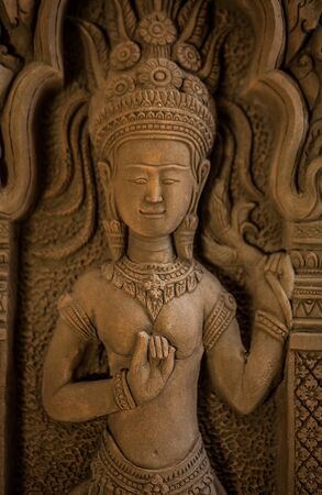 Traditional asian image cut from stone on a wall 