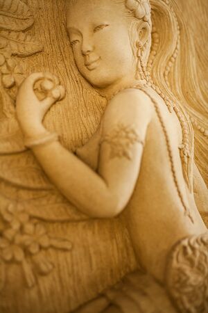 Traditional asian image cut from stone on a wall 