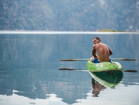 Strong young man in kayak on the picturesque lake in Thailand の写真素材