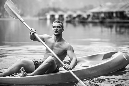 Strong young man in kayak on the picturesque lake in Thailand の写真素材