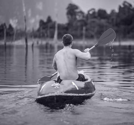 Strong young man in kayak on the picturesque lake in Thailand の写真素材