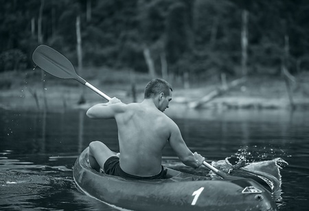 Strong young man in kayak on the picturesque lake in Thailand の写真素材