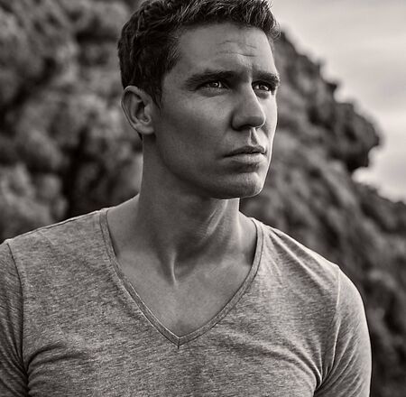 Portrait of adult handsome man against rock background の写真素材