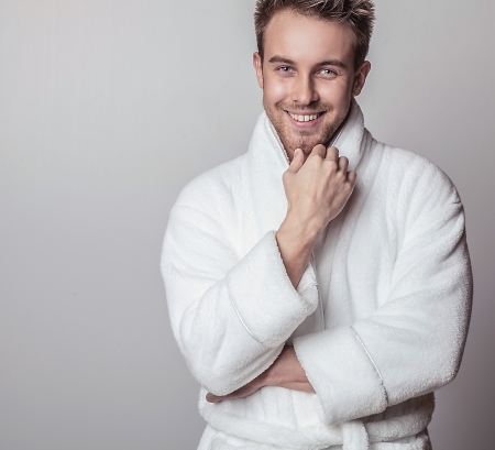 Handsome smiling young man in luxurious bathrobe   の写真素材