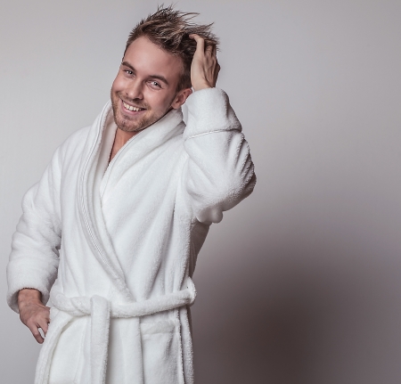Handsome smiling young man in luxurious bathrobe   の写真素材