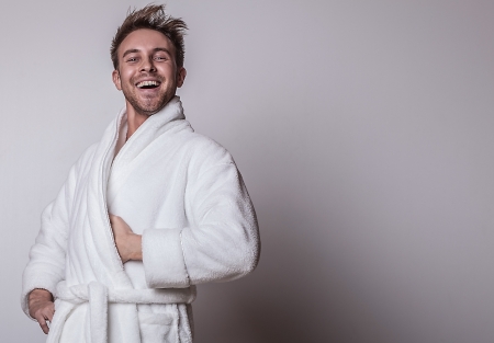 Handsome smiling young man in luxurious bathrobe   の写真素材