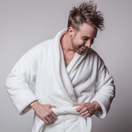 Handsome smiling young man in luxurious bathrobe   の写真素材