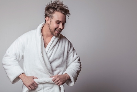 Handsome smiling young man in luxurious bathrobe   の写真素材