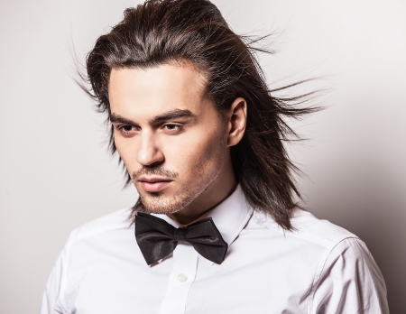 Portrait of handsome long-haired stylish man with bow tie   の写真素材