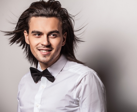 Portrait of handsome long-haired stylish man with bow tie   の写真素材