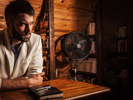 Portrait of young handsome man in white suit near home bar の写真素材