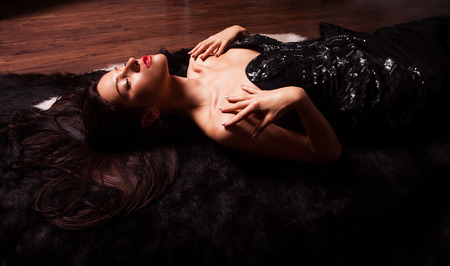 Beauty fashion Women Portrait  Model pose in luxury dress on black fur の写真素材