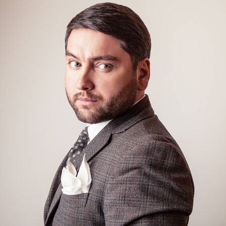 Elegant young handsome man in grey costume. Studio fashion portrait.の写真素材