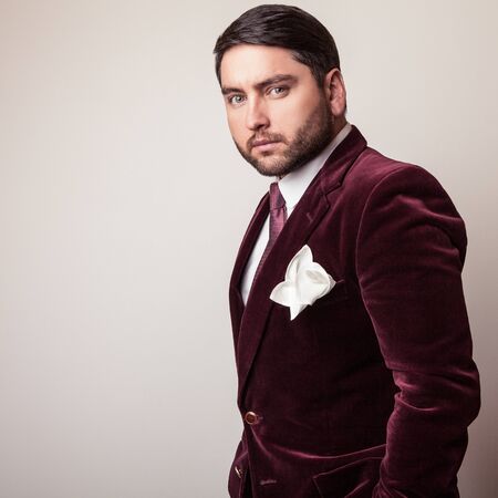 Elegant young handsome man in luxury velvet claret costume. Studio fashion portrait.の写真素材