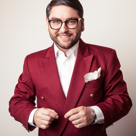 Elegant young handsome man in luxury red costume. Studio fashion portrait.の写真素材