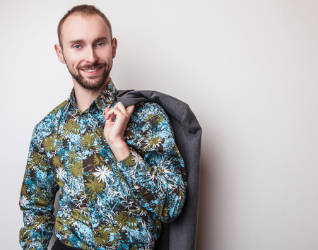 Elegant young handsome man in bright colorful shirt. Studio fashion portrait.の写真素材