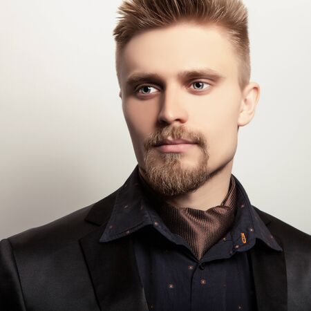 Elegant young handsome man in black costume. Studio fashion portrait.の写真素材