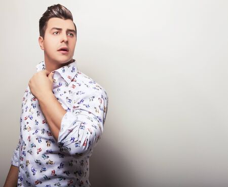 Elegant young handsome man in bright colorful shirt. Studio fashion portrait.