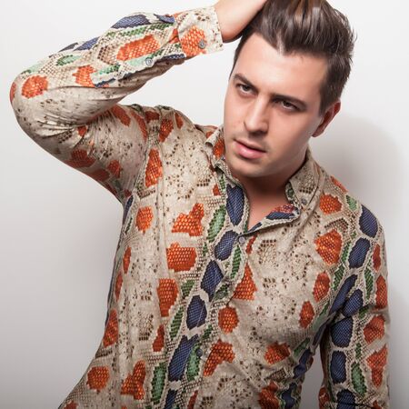Elegant young handsome man in bright colorful shirt. Studio fashion portrait.の写真素材