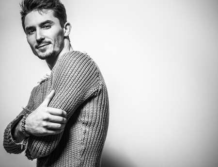 Blackwhite studio portrait of young handsome man in knitted sweater. Closeup photo.の写真素材