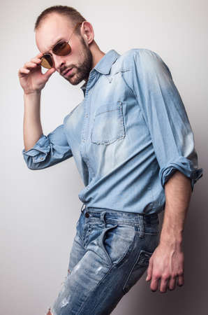 Young handsome man in jeans clothes. Studio fashion portrait.の写真素材
