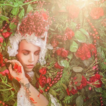 Fairy tale woman portrait surrounded with natural plants and roses. Art image in bright fantasy...