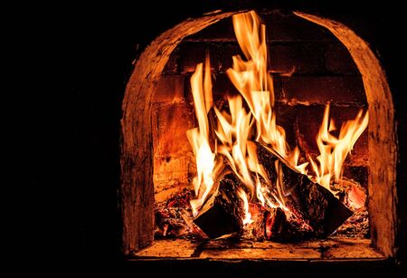 Fireplace with a blazing fire. Photo.