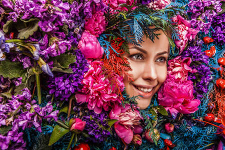 Fairy tale girl portrait surrounded with natural plants and flowers. Art image in bright fantasy stylization.の写真素材