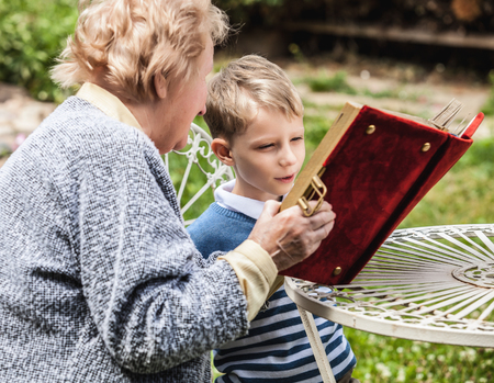 Positive grandmother and grandson spent time together in summer solar garden.の写真素材