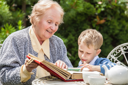 Positive grandmother and grandson spent time together in summer solar garden.の写真素材