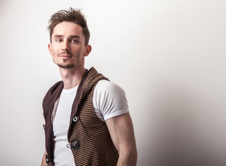 Studio portrait of young handsome man in design brown vest.の写真素材