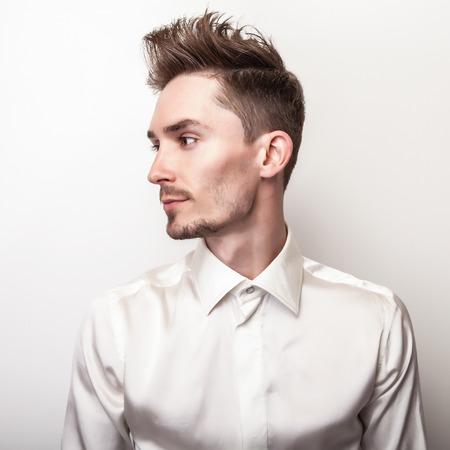 Elegant young handsome man in white silk shirt. Studio fashion portrait.の写真素材