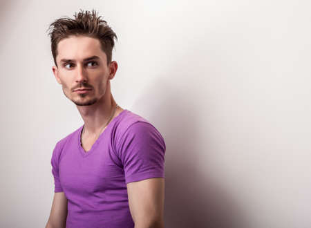 Portrait of young handsome man in violet t-shirt.の写真素材