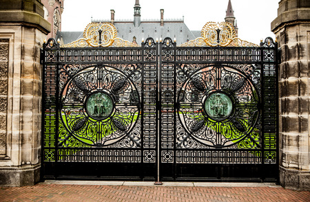 Old forged metal gate in stone colons. Entrance to palace.