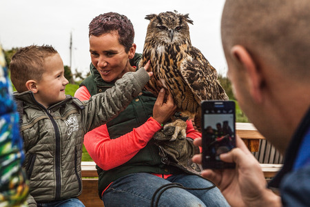 Positive woman shows to children eagle owl  in Muiderslot Muiden castle.のeditorial素材